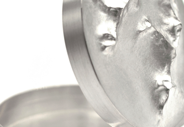 Detailaufnahme einer silbernen Dose mit ziselierter Oberfläche